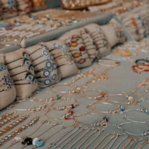 Showcase of colorful handmade jewelry with intricate designs at a market stand.